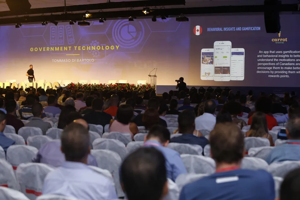 Público acompanhando uma palestra de Tommaso sobre tecnologia