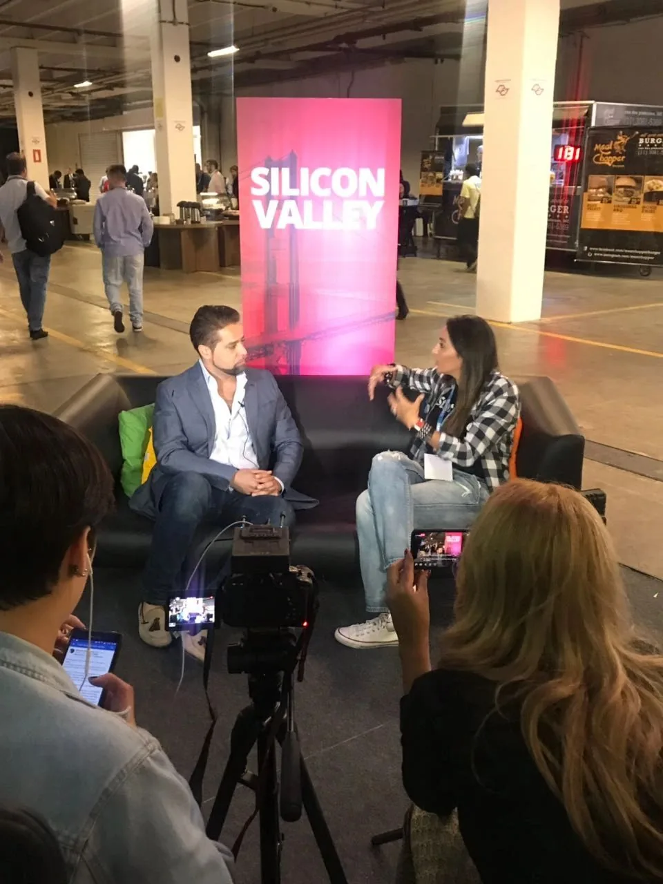 Tommaso in a seated interview with people gathered around