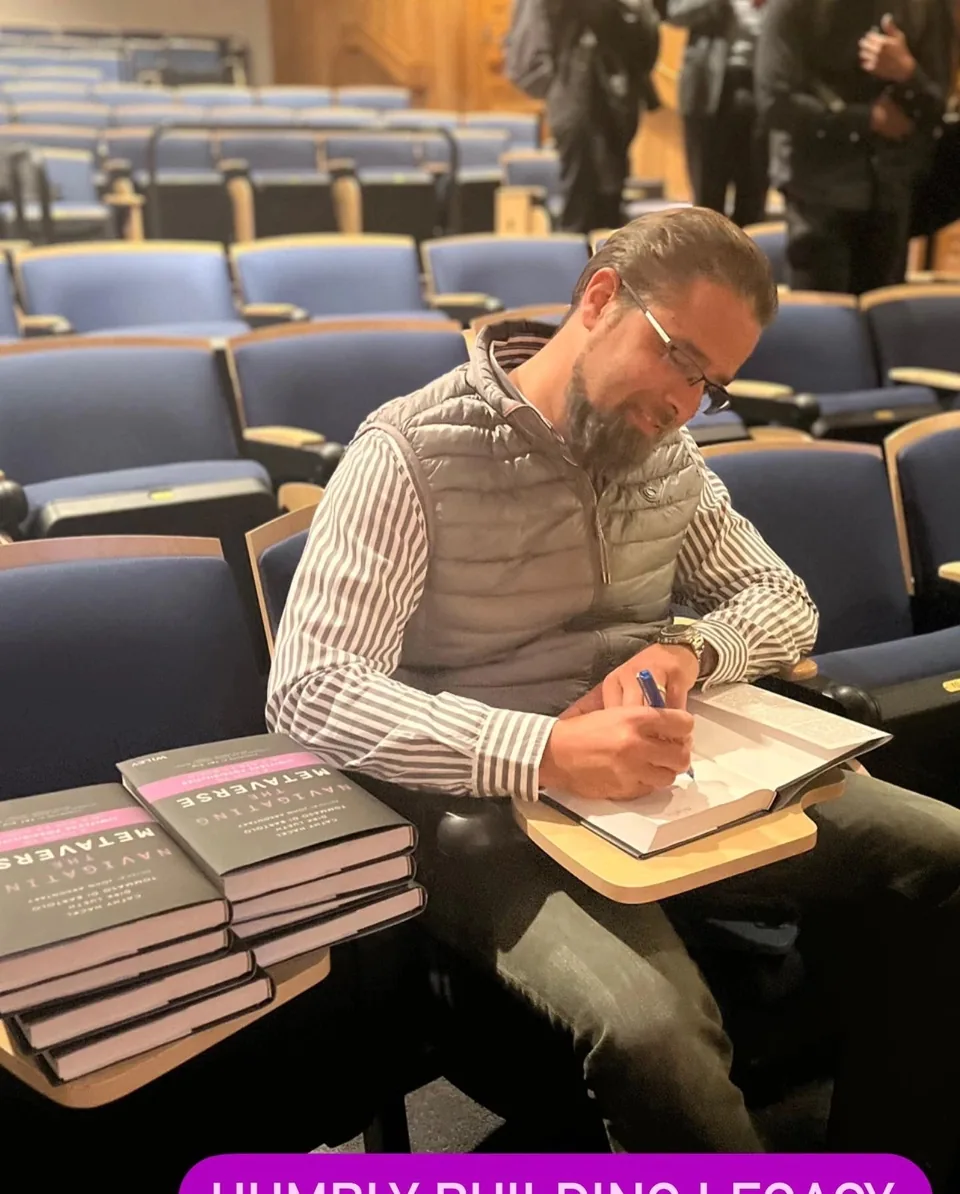 Tommaso signing a copy of his book in an auditorium